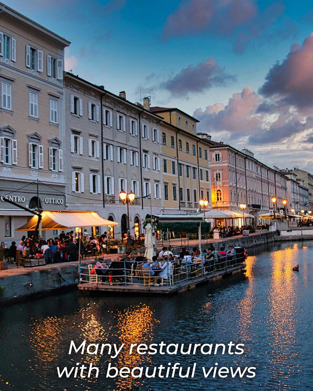Restaurants along the Canal Grande in Trieste, with outdoor seating by the water and historic buildings